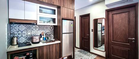 Una cocina moderna con microondas integrado, refrigerador de acero inoxidable y cafetera.