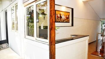 A reception area with a wooden post, a framed painting of horses, and a counter.