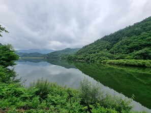 A serene lake surrounded by lush greenery and hills.
