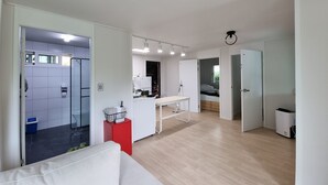 Um espaço de estar moderno e aberto, com cozinha, sala de jantar e um pequeno quarto.