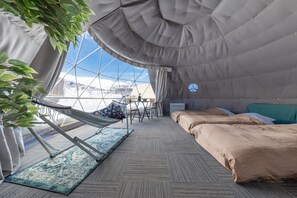 A cozy room with a hammock, a bed, and a view of the mountains through a large window. - From P (Hakuba)