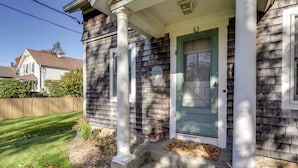 A house with a front porch, a green door, and a welcome mat. - Cozy Historic Wakefield Home Close to Beaches (South Kingstown)