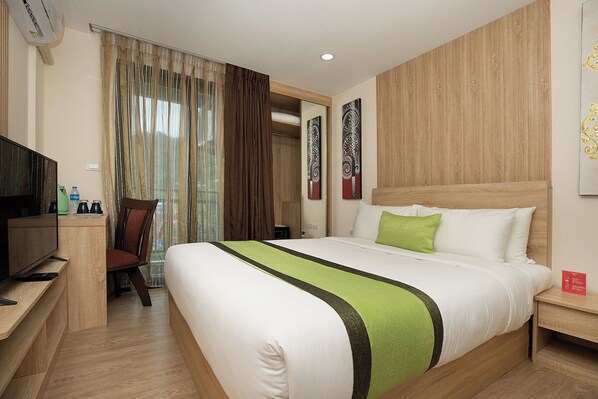 A hotel room with a bed, a television, a desk, and a chair.