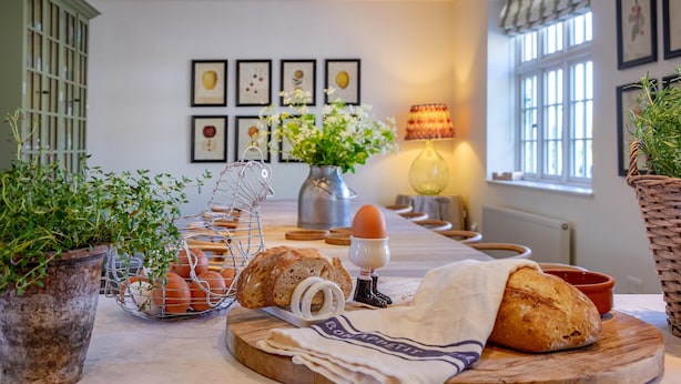 Un piano di lavoro in cucina con pane, uova e un panno.