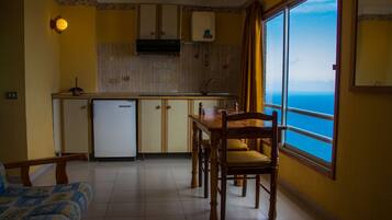 Een koelkast, een kinderstoel, kookgerei, borden en bestek