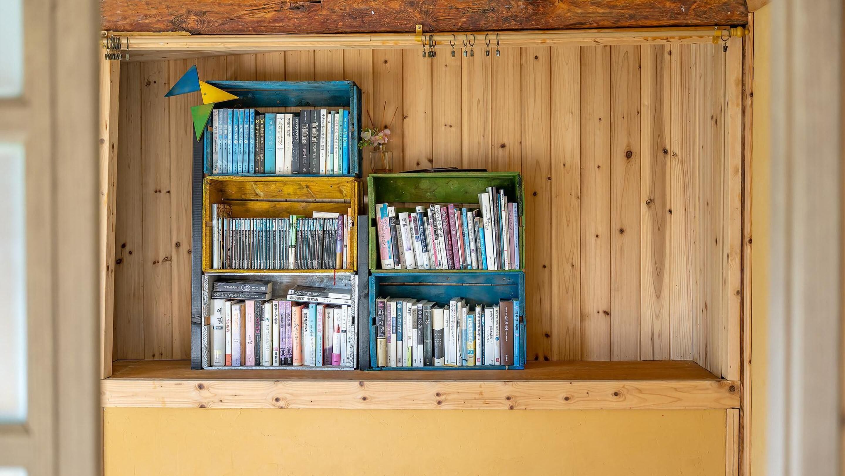 A wooden bookshelf with multiple shelves filled with books.