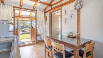 Una cocina con un lavamanos, una cafetera y una ventana con vistas a un jardín.