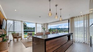 A modern kitchen with a large island, wooden cabinets, and pendant lighting. - Olive 301 · Amazing 2BR Luxury Apt in Alto Las Palmas (Alto Palmas)