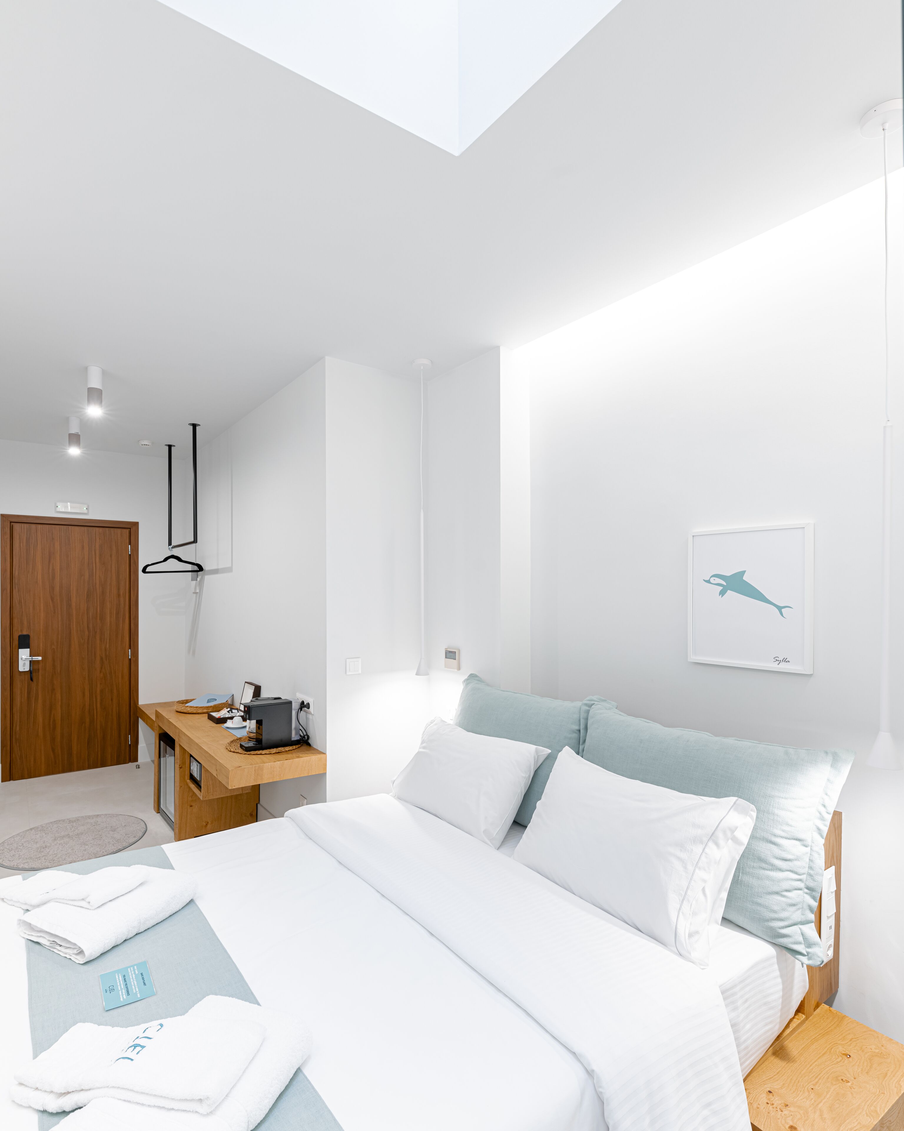 Een moderne slaapkamer met een bed, nachtkastje en een houten garderobe.