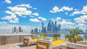 Enjoy breathtaking views of the city skyline from this rooftop terrace with a seating area and modern design.