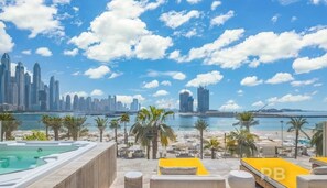 Enjoy breathtaking views of the coastal city skyline from this rooftop terrace, featuring a pool and lounge chairs.