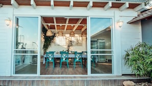 A modern house with a dining area visible through large glass doors. - Kamaya Suites (Emek HaYarden)