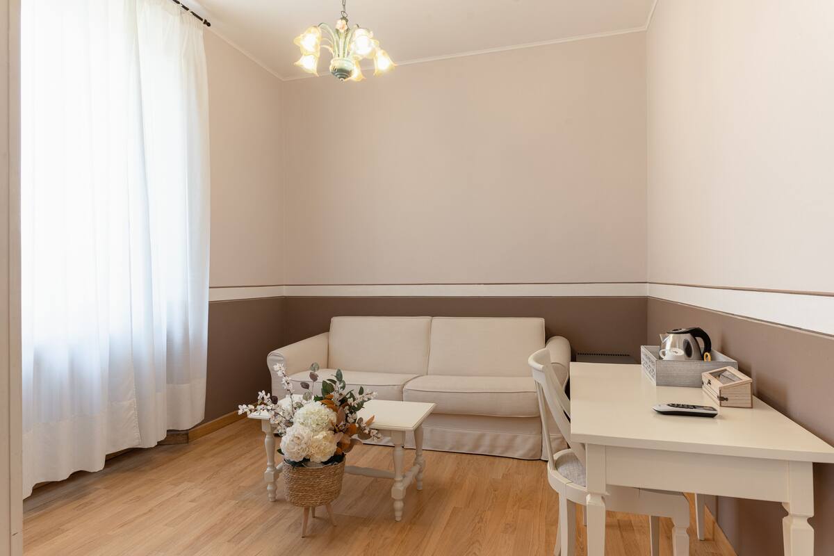 A small, well-lit room with a sofa, a small table, and a decorative basket.