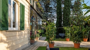 A building with green shutters, a paved pathway, and potted plants. - Villa Romantica (Lucca)