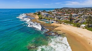 A coastal residential area with beachfront properties, clear blue waters, and a sandy beach. - Beachside at The Entrance (The Entrance)