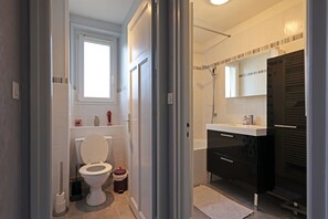 Een bad/douchecombinatie, toiletpapier