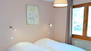 A room with two beds, a window with a view, a wall-mounted light, and a radiator. - 3* Apartment, 2 bedrooms, 6 guests, near slopes, WIFI (La Clusaz)