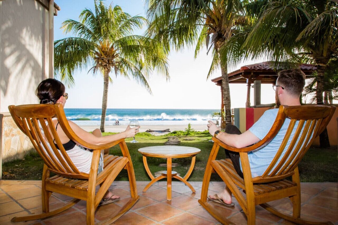 Two people seated at a small round table with a view of the ocean.