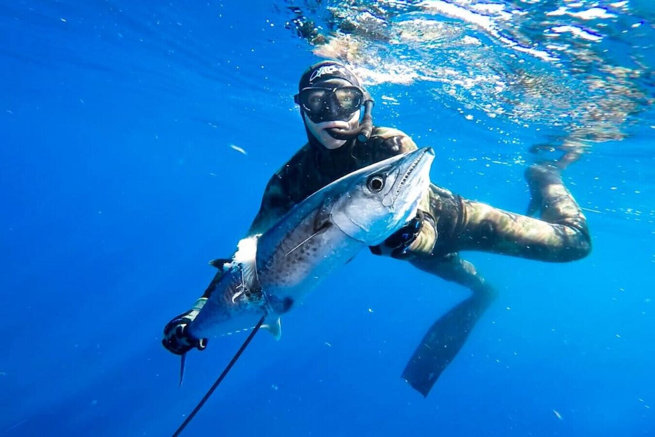 A diver holding a fish underwater.