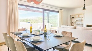 A dining area with a table set for four, chairs, and a view of the outdoors.