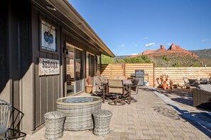 Ein Patio im Freien mit Korbmöbeln, einem Tisch und Stühlen. Auf dem Gebäude steht der Schriftzug 'SEIDONA'.