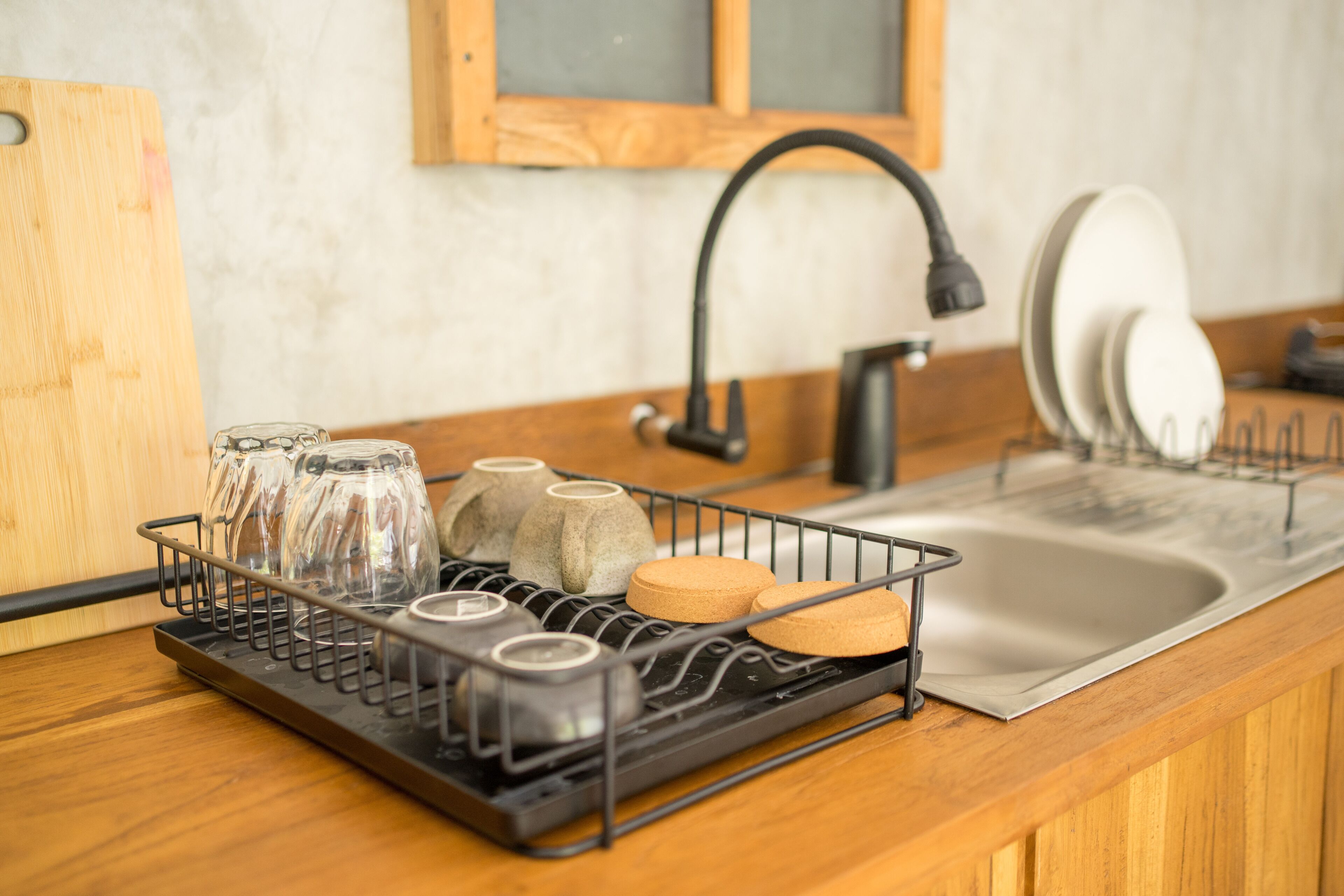 Una cocina con un escurreplatos que contiene vasos y una caja de pan.