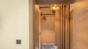 A narrow hallway with a wooden door on the right, a white wall, and a white-framed window. - Yiğit Pansiyon (Sapanca)