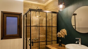 A modern bathroom with a glass-enclosed shower, a wooden vanity, a white sink, and a large mirror. - Yiğit Pansiyon (Sapanca)