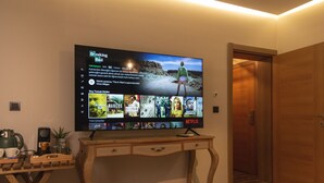 A television mounted on a wooden desk displaying a Netflix interface with various movie thumbnails. - Yiğit Pansiyon (Sapanca)