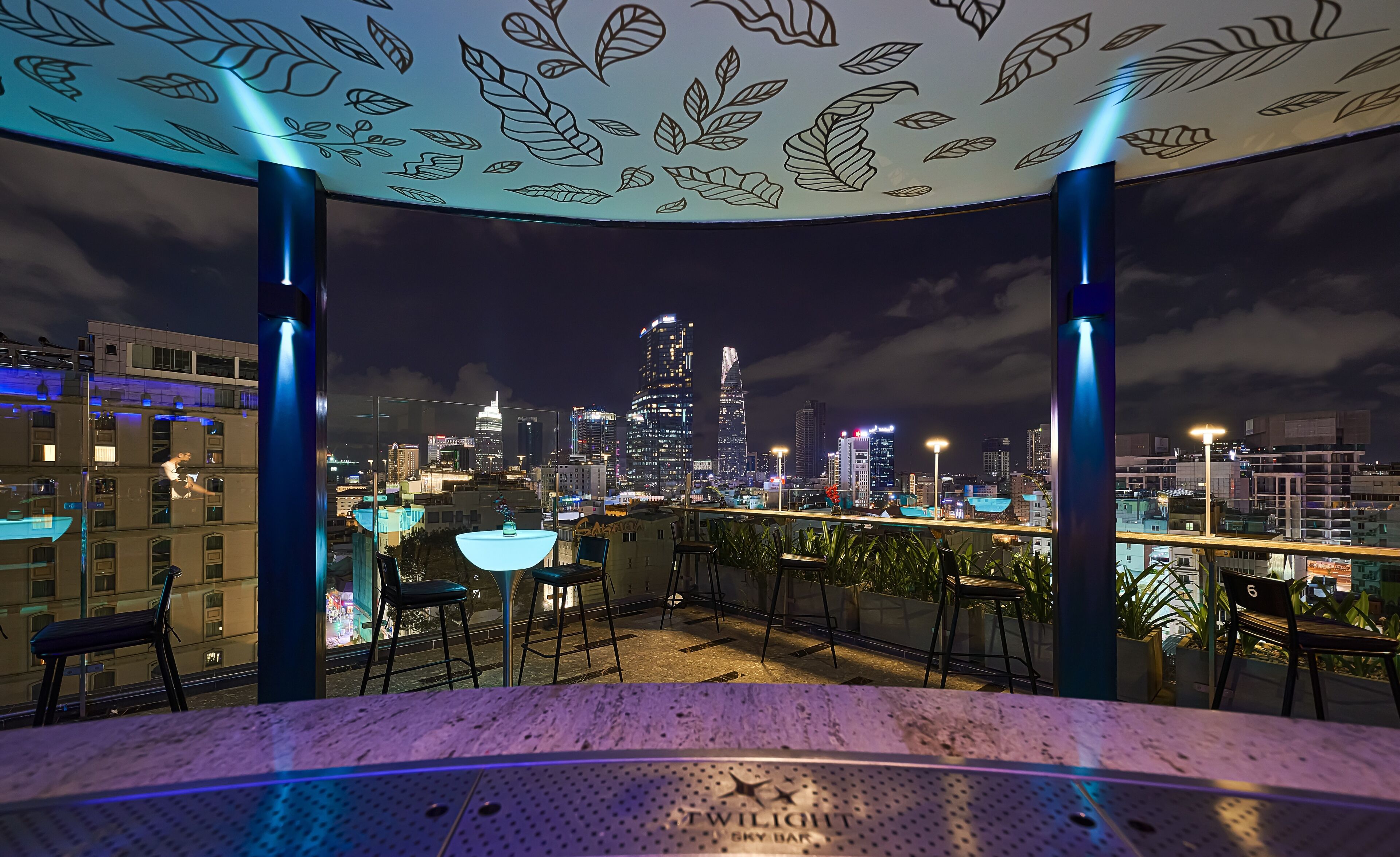 Terraza en la azotea con vistas a un horizonte urbano, que incluye un bar llamado 'Twilight Sky Bar'.