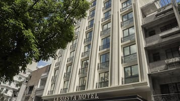 Un hotel de varios pisos con balcones y un cartel que dice 'LA SIESTA HOTEL'.
