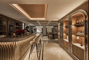 Una cocina moderna con una barra curva, suelo de mármol y muebles de madera.