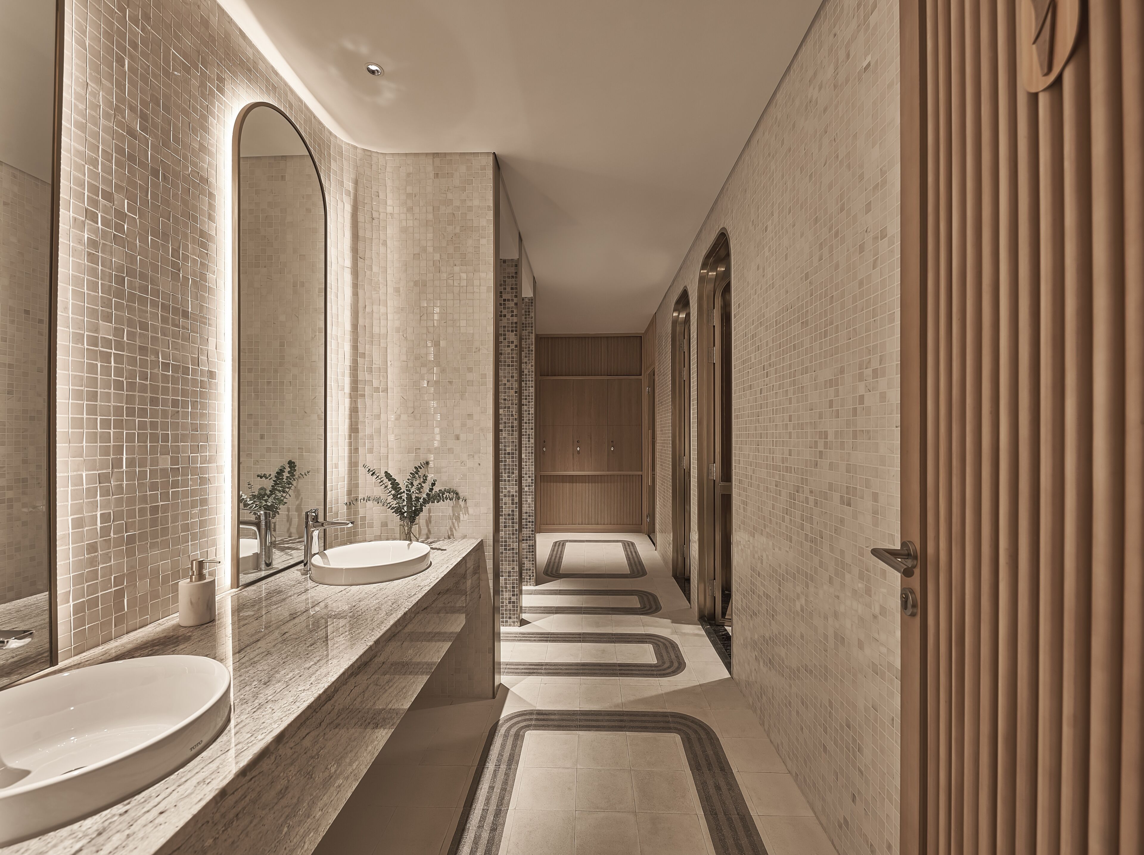 Un baño moderno con un espejo grande, dos lavamanos y una zona de ducha.