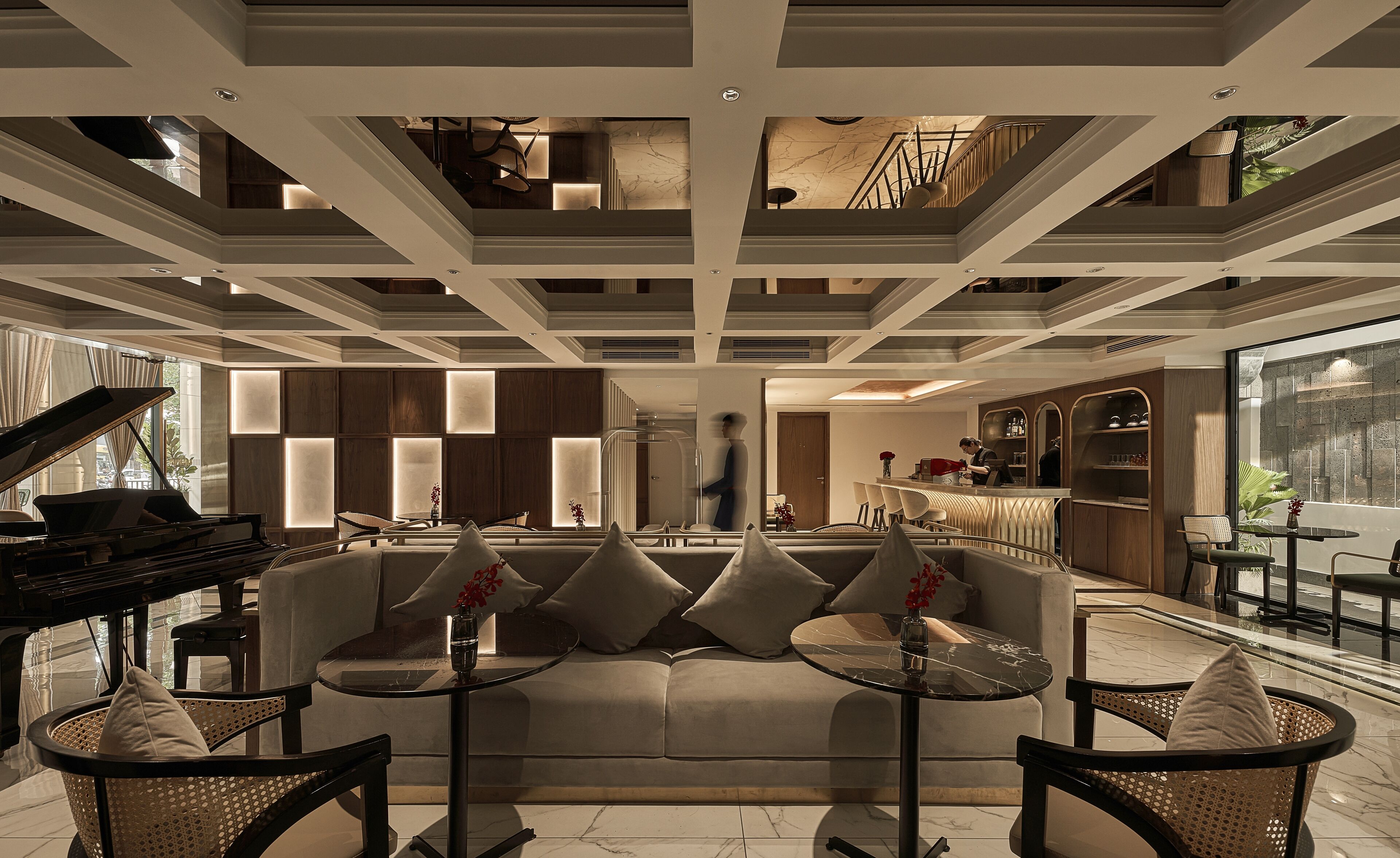 A modern interior with a grand piano, a sofa set, and a bar area.