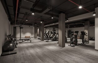 A gym with exercise equipment, a bench, and a mirrored wall.