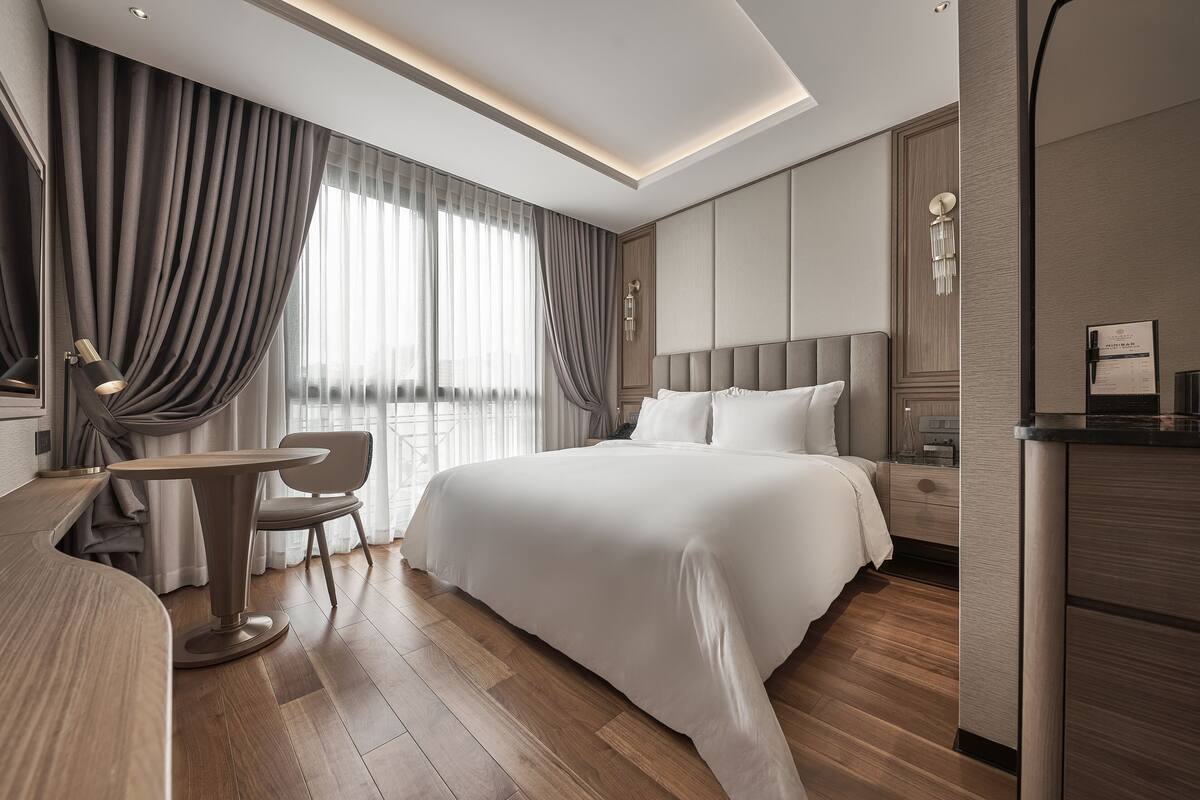 Ein modernes Hotelzimmer mit einem großen Bett, einem Schreibtisch und einem Stuhl.