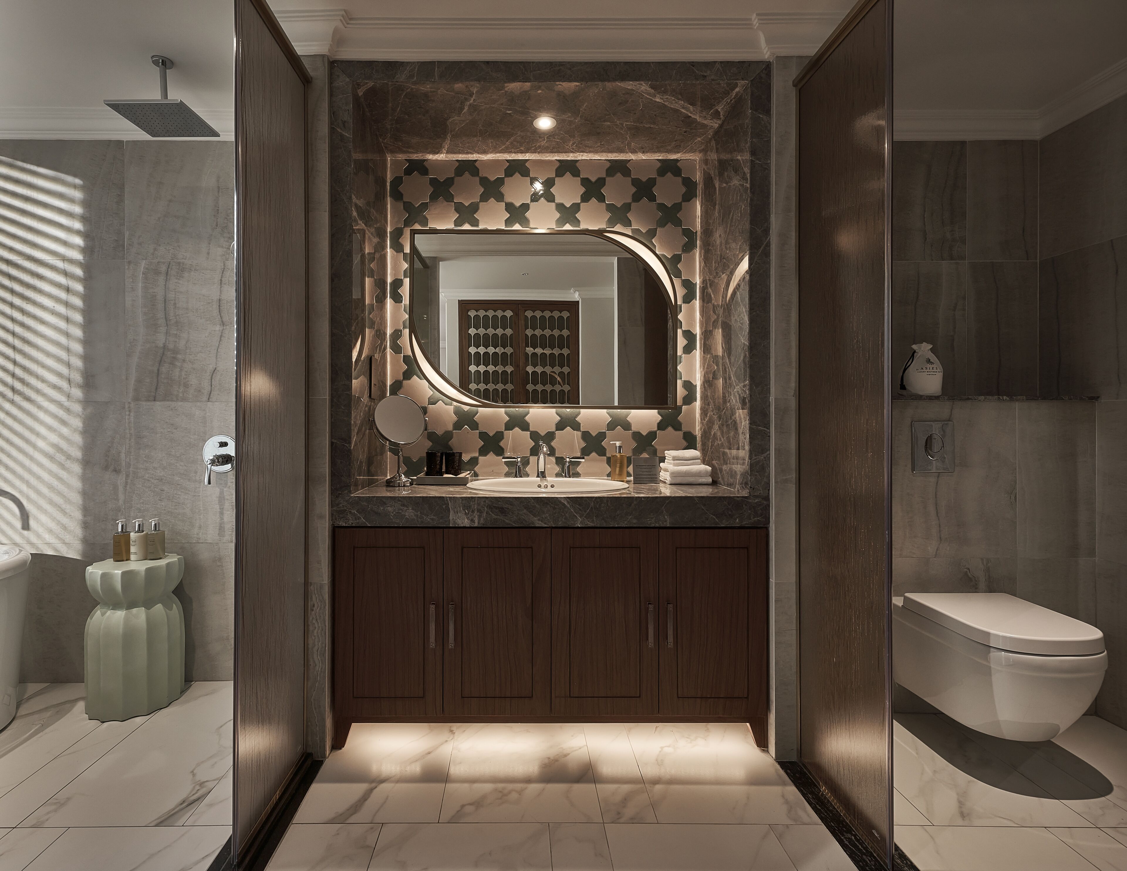 A modern bathroom with a shower, a vanity with a mirror, and a toilet.