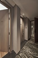 A hotel hallway with a carpeted floor, wooden doors, and a number 512 sign.