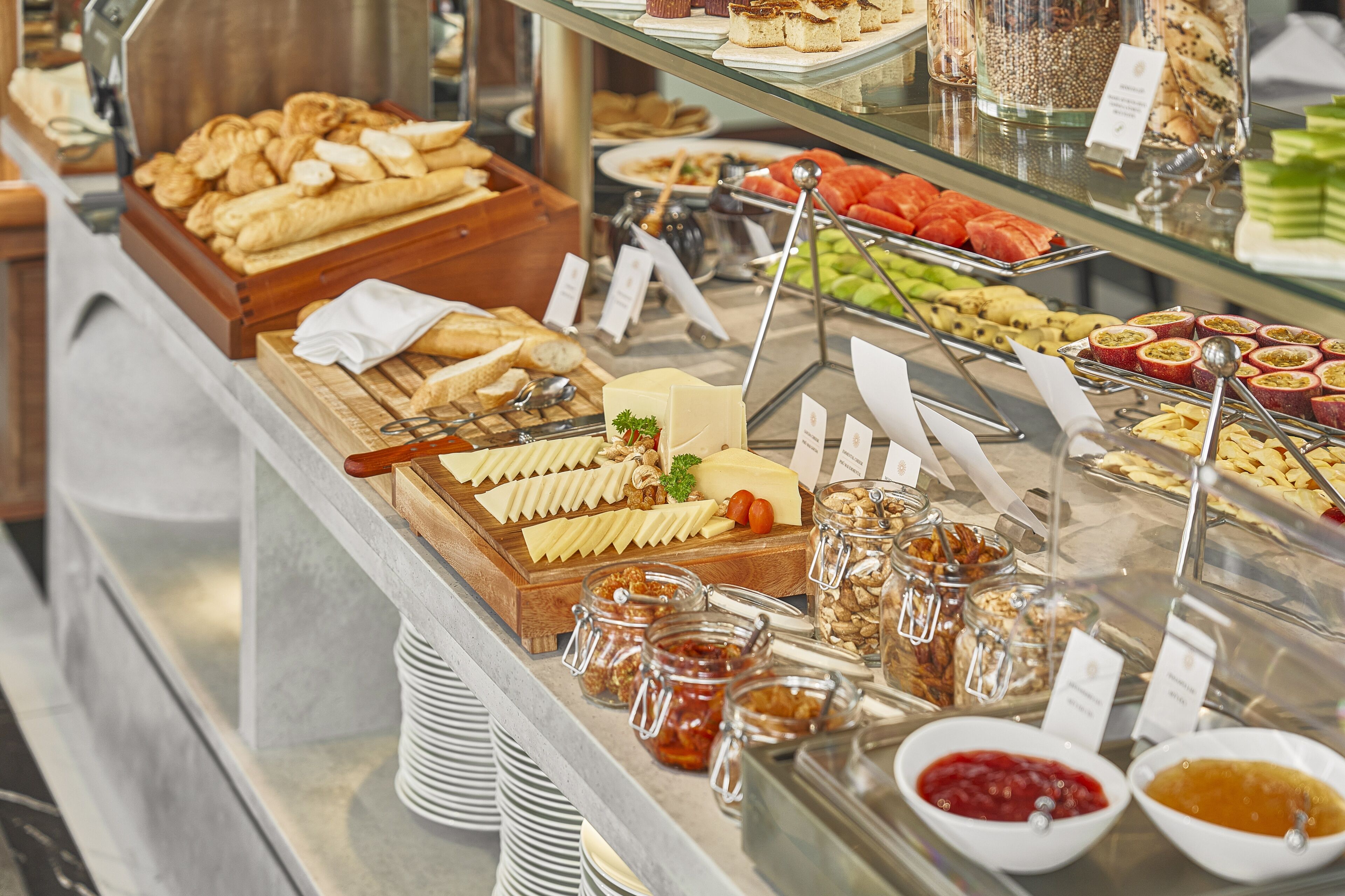 Ein Buffet mit verschiedenen Speisen, darunter Käse, Obst und Gebäck.