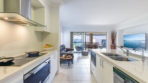 Una cucina moderna con zona pranzo, TV e vista mare.
