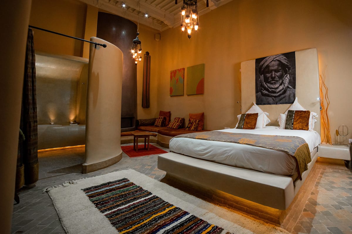Un dormitorio moderno con una cama grande, una zona de estar y vistas a la ciudad.