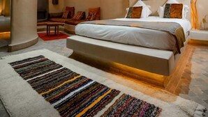 Un dormitorio con una cama grande, una araña y un diseño de techo único.