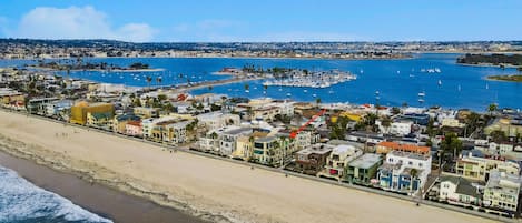 A coastal town with a beach, marina, and residential buildings.