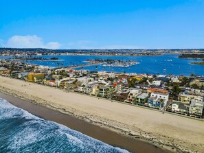 A coastal town with a beach, marina, and residential buildings.