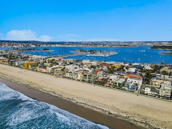 A coastal town with a beach, marina, and residential buildings.