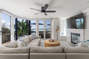 Una sala de estar moderna con un sofá color beige, una mesa de centro de madera y una chimenea.