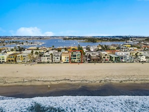 A coastal town with a beach, houses, and a marina.