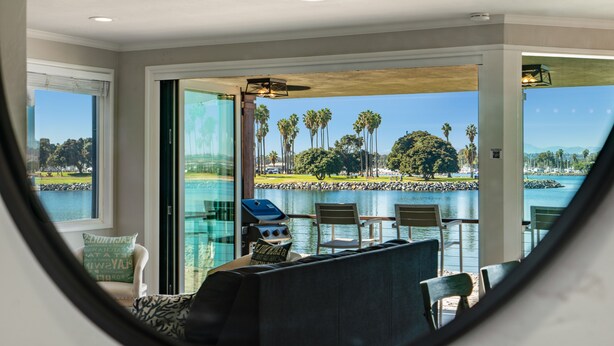 Une chambre avec vue sur un lac, un espace extérieur aménagé et un barbecue.