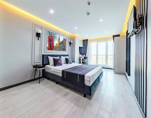 Une chambre d’hôtel moderne avec un grand lit, un bureau et une vue sur le paysage urbain par la fenêtre.