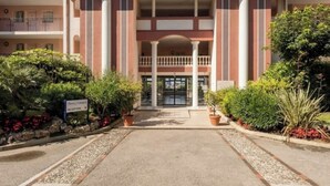 L’entrée d’un hôtel, avec une arche centrale, des colonnes et un espace d’accueil.
